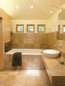 The design for this bathroom/closet renovation included bumping up ceiling heights and swathing surfaces in neutral-toned, natural materials to create a serene, modern, and unified environment.