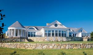 The variety of rooflines and room projections on the oceanfront elevation help make the house appear smaller than it really is.