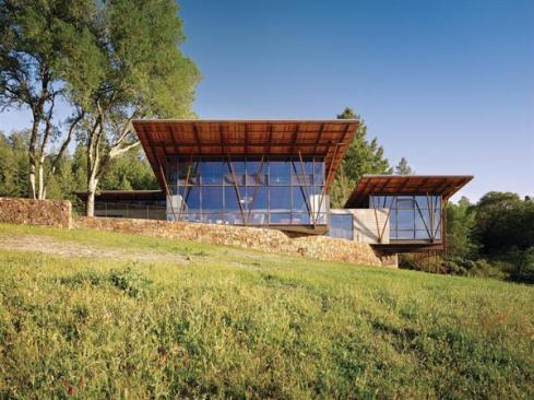 Long overhangs and high glass walls expose the compounds wood-and-steel roof structure