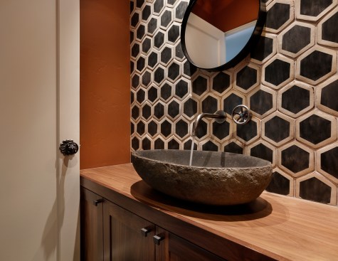 A wall to wall vanity houses below-counter storage. The oval stone sink is generously sized. 