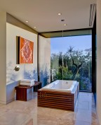 An ipe-clad bathtub and a wall-height glass window with garden views reinforces this master bath's connection to the outside.