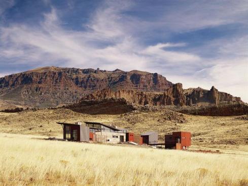 The house's silhouette echoes the forms of the surrounding landscape. 