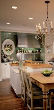 The oval window next  to the stove lets light pass through the interior wall. Placement of the window also marks the cneter line along which the main living spaces  dining, kitchen and family are aligned.