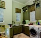SPREAD OUT: A utility room justoff the kitchen has its own separate entrance to the outside, and provides plenty of space for bulk storage, countertop projects, and heavy-duty cleaning jobs.  A wall-mounted ironing board from Broan (inset) folds away when not in use.
