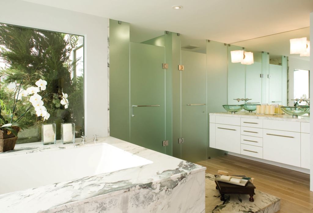 White lacquered custom cabinets are a simple foil to the heavily veined marble. The cantilevered cabinet supports twin vessel sinks. “I use a floating vanity pretty often,” says architect Mark English, “because I like seeing the floor continue.”