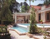 A new multipurpose pool house adds function and form to this backyard. Sited to block neighbors' views of the pool, as well as north winds, the structure provides a shaded place to gather, cook, and dine under its large, umbrellalike roof.
