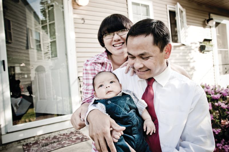 FINALLY ARRIVED: Cambodian-American Tooch Van, wife Chorvy, and son Winston, outside the Lowell, Mass., home they bought with help from a local housing group.