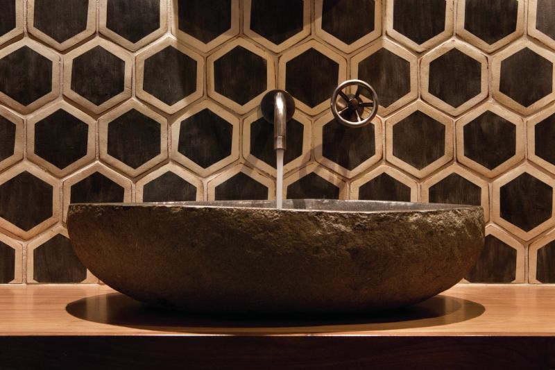 Bold wall tile, a stone sink, and a simple wall-mounted fixture might not work in a bigger or busier bath, but here, they pack a visual punch.