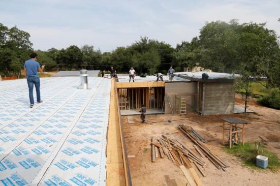 The nearly flat roof has internal gutters you can see on the right then the fascia is steel.
