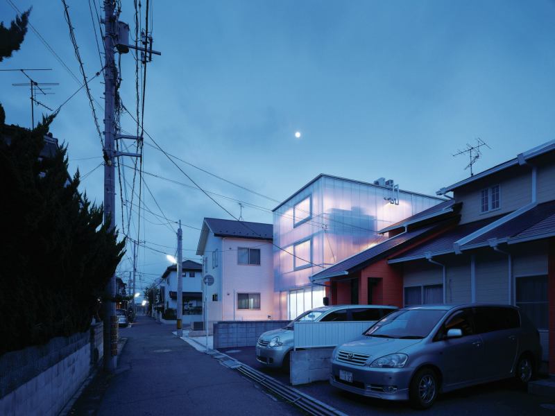 Seen here at dusk, the interior lights in the House in Tousuien make the polycarbonate-clad structure glow amid the quiet Hiroshima neighborhood.