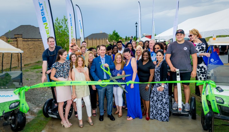 Tim Johnson and Susan Brown, second from left, with residential developer Land Tejas and partners cut the ribbon to officially open the 12-foot GreenBoLT trail system in Balmoral as dozens of Realtors and well-wishers cheer on.