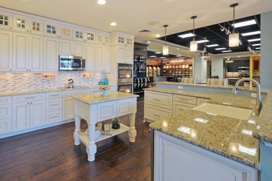 Schell Brothers’ Design Studio displays an updated kitchen that’s casual and welcoming. Painted white cabinets, apron-front sink, and rustic floor work in tandem with both backsplashes for an updated look. Stacked cabinets are a fresher alternative to staggered ones. Builder: Schell Brothers, Rehoboth Beach, Del.; Design Studio: Success Strategies; Merchandiser: In-house Design Studio