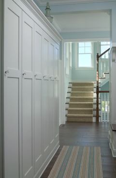 This entry hall is transformed into a space both serene and serviceable thanks to a wall of cabinetry for plenty of coats, backpacks, and bags. The storage area is accompanied by small benches, hooks, and simple shelving (next slide) that pack utility into minimal space. Project: Arcadia, South Haven, Mich.; Architect: Visbeen Architects, Grand Rapids, Mich.; Builder: David C. Bos Homes, Spring Lake, Mich.