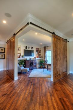 Barn doors are a popular solution for dividing spaces, especially where there might not be room for a hinged door. These are built with knotty alder, which complements the hickory floors (finishes are Mannington and Mountain View in Fawn). Builder: Schumacher Homes, Charlotte N.C.; Merchandiser: Kay Green Design, Orlando, Fla.