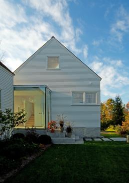 A glass box adds a punch of modern design and some visual juxtaposition to this home’s traditional farmhouse forms. Project: Casco Bay, Freeport, Maine; Architect: Elliott + Elliott Architecture, Blue Hill, Maine; Builder: Stroudwater Construction, South Portland, Maine