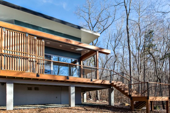 On the western elevation, sliding wood screens, hung on the very outside of the wrap-around porch, can slide easily into a closed position to block the summer sun and protect the house from excessive heat gain.