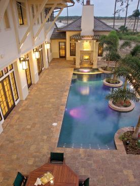 POOL VIEW: As seen from the upstairs loggia, the dramatic pool along the back edge of the terrace features concrete planter columns within its waters and an integral spa at the far end, giving ready access to the owners from the master suite just beyond it.