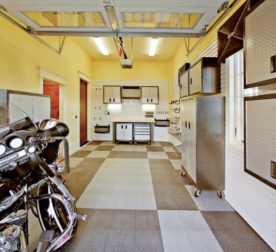 FULLY LOADED: A completely equipped workshop, including a convenient half-bath featuring hands-free plumbing fixtures and fittings, occupies the single-bay garage on one side of the motor court. A wall-hung and modular/mobile system of cabinets, workbenches, and other storage options from Gladiator GarageWorks serves a variety of needs and leaves enough floor space for tinkering with a motorcycle, an ATV, or maybe just the lawn mower or a busted sprinkler head.