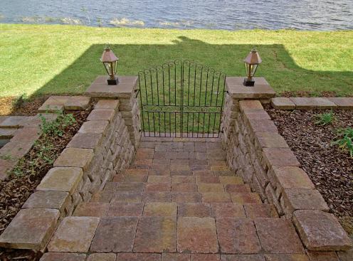 LAKE ACCESS: It would be foolish not to take advantage of the spring-fed lake behind the house, if not for fishing than at least for a relaxing canoe excursion or troll in the ski boat. A pair of wide-set, concrete-paver steps, fashioned from materials supplied by Oldcastle Architectural, lead from the pool terrace to the grassy swale fronting Lake Burden. A third set of steps leads directly from the guest suite's private patio to the boat dock.