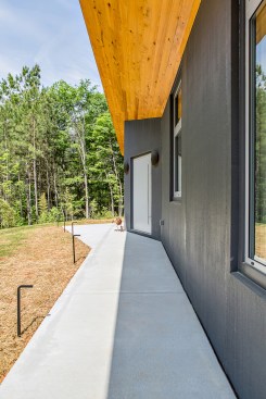 A simple, linear walkway leads from guest parking to the front door. The angled wall section signals the stopping point.