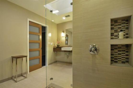 Niche+shelves+are+positioned+at+each+shower+head%2c+for+both+standing+and+sitting+access.+