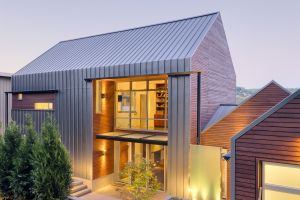 The protective shell of this lakefront home comes by way of a standing-seam metal roof that wraps down two sides. Cut away that thick skin, however, and you discover a softer, warmer layer of horizontal red cedar. Architect: Johnston Architects Builder: Schuchart Dow