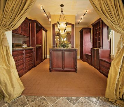 DRESSED UP: The master bath transitions into an impressive closet and dressing area, highlighted by a split set of built-in cabinets but also featuring a separate makeup vanity and full-size set of laundry equipment.