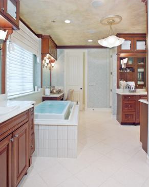 PEACEFUL DIVISIONS: His and hers vanities, sinks, and separate toilets prevent gender wars in the master bath. Kohler’s spacious infinity tub with ceiling-mounted faucet, however, is big enough to share. The surround is Savoy tile by Crossville.