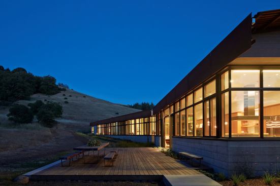 The kitchen and living space look out onto the back deck and the surrounding landscape.