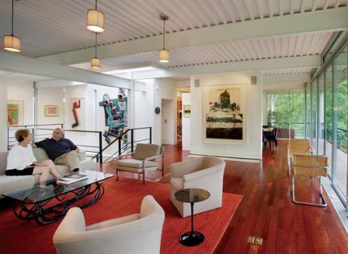 Glass curtain walls float within the structural cube, leaving a narrow covered deck around much of the perimeter