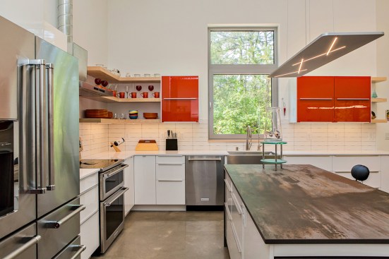 The Serdars’ kitchen is an exercise in simplicity, including natural wood open shelving above Silestone® counters. Dekton® covers the island, recalling worn metal.