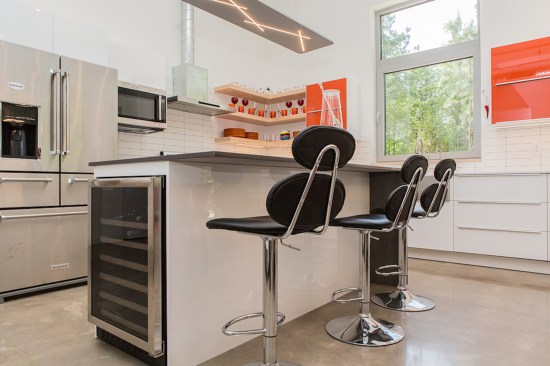 Custom designing every square foot for space and the homeowners' lifestyle, Schechter turned the end of the kitchen island into a wine cooler.