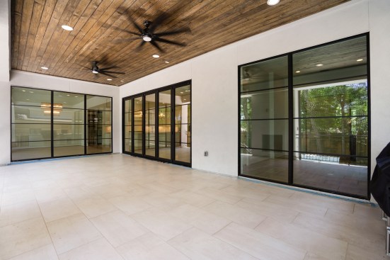Flushed Fireplace with accordion doors leading to outdoor kitchen space