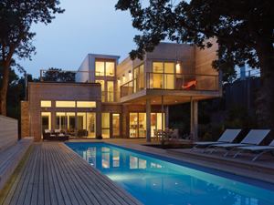 The back of the house opens onto a pool deck and covered dining terrace.