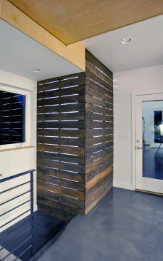The same translucent polycarbonate from the pantry lines the inside powder room walls so light can filter between the dark wood slats, but sound and water stay inside.