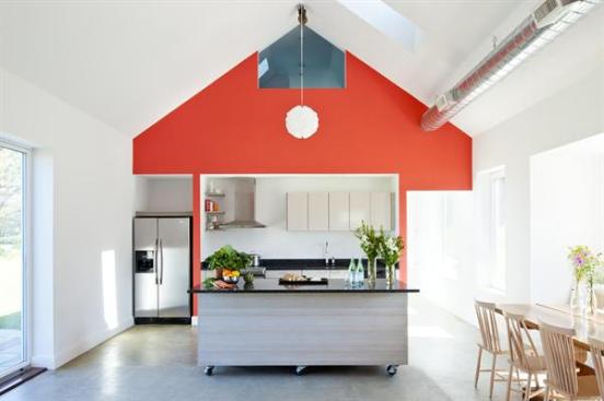 The iconic shape and playful red color of the exterior gables are carried through to the interior kitchen and living room walls.