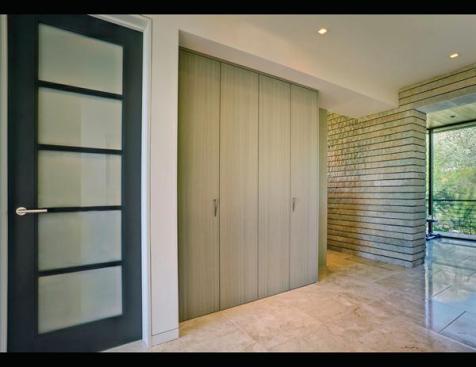 Closet+doors+of+Koto+veneer+conceal+storage+for+towels.