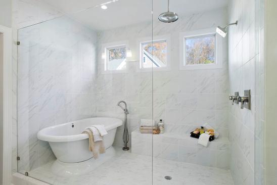 Freestanding tubs are catching on. This one, placed inside the frameless glass shower, offers a new twist on the wet room, complete with a rain shower head. Builder: Schumacher Homes, Charlotte N.C.