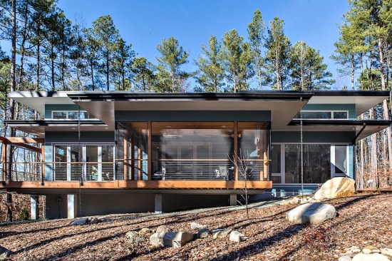 A cantilevered screened porch appears as if it’s floating above the natural landscape.