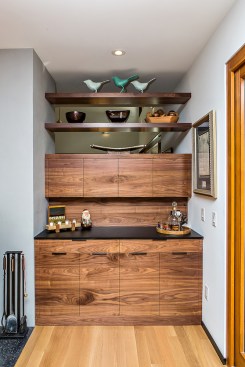 In the dining area opposite the kitchen, a custom-designed, designed, mid-century-inspired cocktail bar complements the kitchen cabinetry. .
