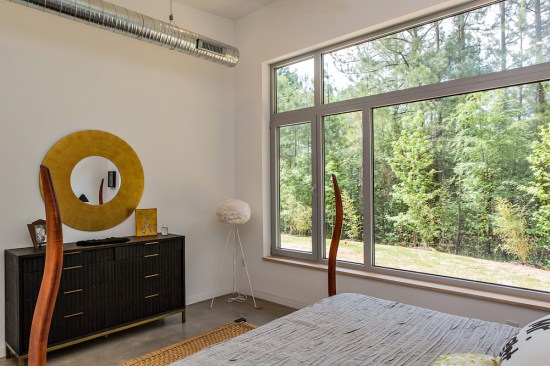 An oversized window in the master bedroom lets the Serdars wake up to a view of the nearby forest.