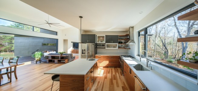 The long window in the kitchen maintains a visual connection with the southern portion of the property. Architect Arielle Condoret Schechter designed the walnut cabinets.