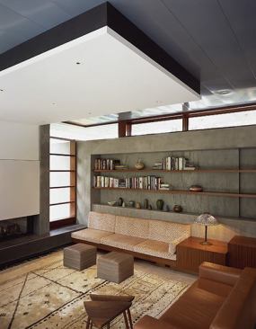 The concrete spine slices through the house, forming a wall with shelving nooks in the family room. Built-in furniture adds to the sense of comfort and continuity.
