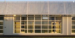 The glazed corridor wall allows sunlight to hit the floor inside, and the perforated-metal cornice serves not only as a modest sunshade, but also as a deterrent to climbers.