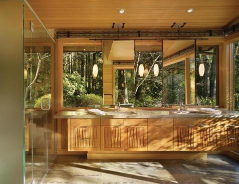 Over the sinks, architect Nils C. Finne added large mirrors, suspended in thin steel frames, that reflect patterns and light from the continuous windows behind them. They contribute a moment of glamour to an otherwise restrained room, and they do sway, underscoring the sense of hovering lightly in space. 