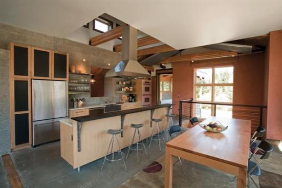 Concrete plays a central role in this eco-friendly kitchen. The walls open-face concrete block is a rugged counterpoint to the gleaming wax finish on the concrete floors and the sparkle of glass-flecked, polished-cement countertops.