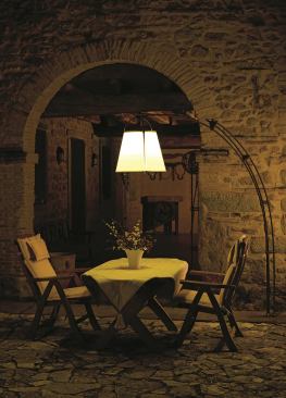 The outdoor floor lamp, Twilight, is made from aged-brass tubing features an aged-copper reflector and a methacrylate transparent conical shade extending from a aged-copper-covered concrete base. The base is 28 inches in diameter and the lamp is 79-inches tall.