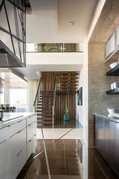 The floating-riser staircase is configured in a sawtooth pattern for a cantilevered look. It is supported by steel runnerse encased in wood.