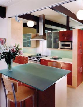 Red-stained plywood cabinetry helps reflect light, making the most of the natural lighting afforded this compact kitchen, which earned a 2009 Custom Home Design Award. Project: Eichler Kitchen, Palo Alto, Calif; Architect: Anne Phillips Architecture, Berkeley, Calif.