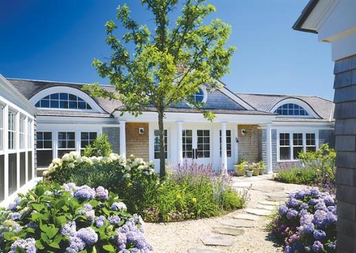 The front facade and guest wing meet to create an entry courtyard landscaped by Kris Horiuchi.